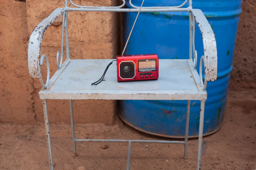 Rotes Radio auf Metalltisch vor blauer Tonne