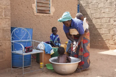 Eine Mutter während Sie Ihre Kinder wäscht hört Radio